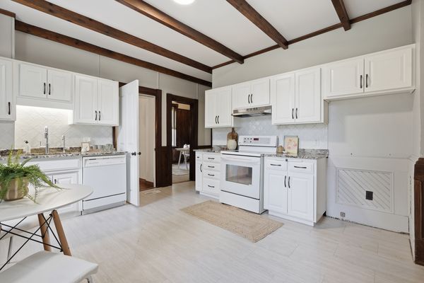 Kitchen with white cabinetry and exposed wood beam ceiling