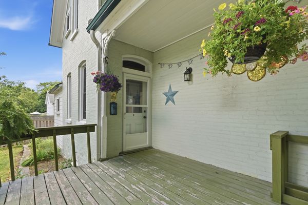 Covered rear porch with hanging petunias